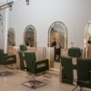 Cadeiras de atendimento e espelhos em arco no interior do salão Seu Espaço em São Caetano do Sul