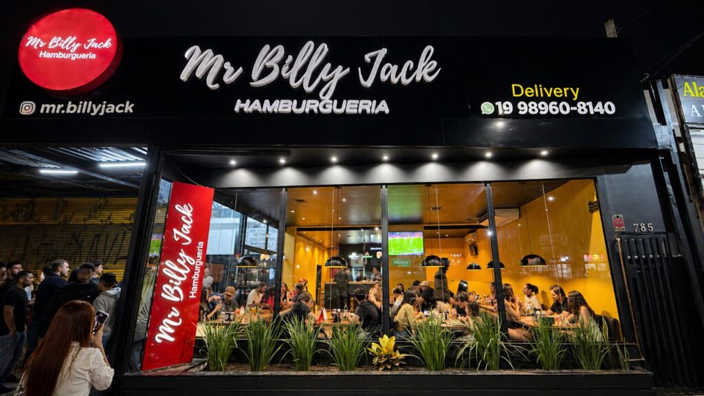 Hamburgueria Mr Billy Jack em Campinas com fachada iluminada e clientes na reinauguração no Campo Grande.